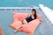 Portrait sexy asian girl in nice black bikini lay down relaxing on bean bag in part of cruise yacht with background of blue water