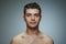 Portrait of shirtless young man isolated on grey studio background