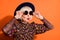 Portrait of shocked amazed surprised cool grandmother look copyspace touch sunglasses  on orange color