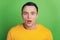 Portrait of shocked speechless guy open mouth stunned face on green background