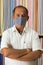 Portrait of shopkeeper looking at camera in cloth store wearing protective medical mask to prevent coronavirus or covid