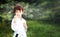 Portrait of short haired 7 years old girl in white kimono making karate kata training outdoors. Martial arts. Sport and activity