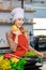 Portrait shot of Asian young beautiful female chef housewife wears white tall cook hat and apron standing smiling posing with