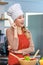 Portrait shot of Asian young beautiful female chef housewife wears white tall cook hat and apron standing smiling posing thinking