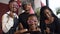 Portrait shot of four african girls making selfie on the smart phone.