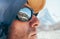 Portrait shot of high altitude unshaven happy mountain hiker in baseball cap and hood with snow peaks and mountain range beside