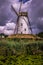 Portrait shot of an old windmill by the canal of Damme