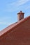 Portrait shot of red brick chimney against blue sky
