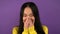 Portrait of a shy Asian woman in a yellow sweater. woman on purple isolated background. 4K