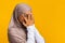 Portrait of shy black muslim girl in headscarf peeking through fingers