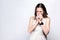 Portrait of sick cold woman with freckles and white dress and smart watch on silver gray background.