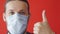 Portrait of a sick man wearing medical mask at red background. Coronavirus concept. Protect your health