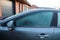 A portrait of the side of a car which completely frozen. The driver side window is frozen shut. The ice first needs to melt or be