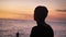 Portrait silhouette of young man enjoying beautiful sunset on the background of the ocean