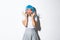 Portrait of silly asian girl in blue wig, glamour makeup, showing macaroons over face and pouting with kawaii look