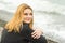 Portrait of sitting on beach mysteriously smiling girl in cloudy weather