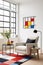 Portrait size of A living room with a Piet Mondrian-inspired armchair as the centerpiece. The armchair is geometric and colorful