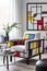 Portrait size of A living room with a Piet Mondrian-inspired armchair as the centerpiece. The armchair is geometric and colorful