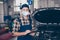 Portrait of skilled guy mechanic writing list car repair maintenance wearing gauze mask goggles in garage