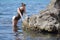 Portrait of skinny young woman in one-piece swimwear at the sea