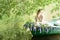 Portrait of slavic or baltic woman with wreath sitting in boat with flowers. Summer