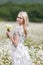 Portrait of slim girl with bouquet of chamomile in her hands