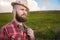 Portrait of a sly cheerful bearded Jewish man hitchhiker in a hat and shirt against the backdrop of a suburban landscape