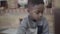 Portrait of small african american child boy focused playing and having fun with toys in living room.