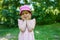 Portrait of small attractive lovely cheerful girl in pink hat have fun and walking in the park