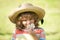 Portrait of a small blond boy in straw hat, closeup. Cute kids face with plumeria flower. Positive emotional child in