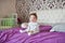 Portrait of a small child sitting on the bed. Portrait of a little baby sitting on the bed. Portrait of a small child sitting on a