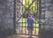 Portrait of a small four year old girl at a old iron gate in a park in autumn.