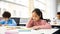 Portrait of small girl sitting at desk and thinking