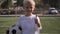 Portrait of a small seven-year-old boy on a soccer field with a soccer ball.