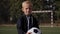 Portrait of a small seven-year-old boy on a soccer field with a soccer ball.