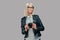 Portrait of a smart blonde female photographer in a white blouse and black leather jacket posing with a camera at a