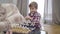 Portrait of smart Caucasian boy setting chess pieces on board. Little cute child starting playing with unrecognizable