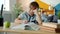 Portrait of smart kid doing homework at home studying writing reading at desk