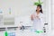 Portrait smart young asian teen scientist girl on white coat role playing in school chemical science lab standing happy smile