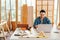 Portrait of a smile Asian male father sitting and working with a laptop on the table with the instrument of measure and working