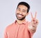 Portrait, smile and peace sign of Asian man in studio isolated on a gray background. Face, v hand emoji and happy