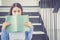 Portrait of smile young asian woman hide face behind book with leisure