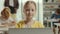 Portrait smiled little girl sitting on the desk with laptop in a class during computer science lesson looking at the