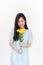 Portrait of smilimg asian girl holding bouquet with yelliow flowers with copyspace