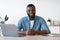 Portrait Of Smiling African Freelancer Man Sitting At Desk In Home Office