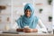 Portrait Of Smiling African Islamic Lady In Hijab Using Smartphone In Office