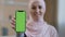 Portrait smiling arabian lebanese girl muslim islamic woman in hijab hold smartphone in front show mobile phone with