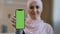 Portrait smiling arabian lebanese girl muslim islamic woman in hijab hold smartphone in front show mobile phone with