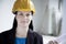 Portrait of smiling architect in a hardhat holding a rolled up blueprint indoors, close-up