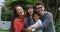 Portrait of smiling asian parents embracing laughing son and daughter in garden